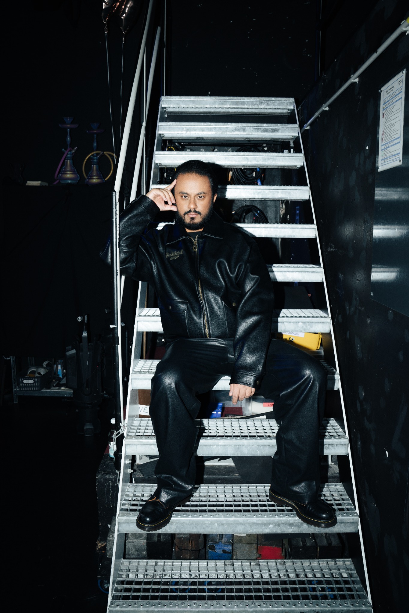Ravi Walia in schwarzer Lederjacke auf einer Backstage-Treppe